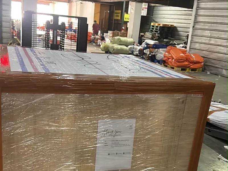 Koli besar terbungkus stretch film di atas pallet biru